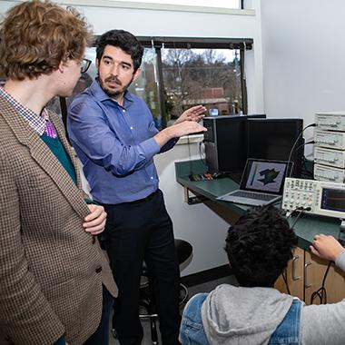 Professor Yuri Rodrigues instructs two engineering students